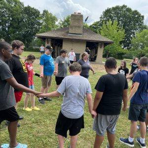 A group of kids and adults holding hands in a circle